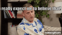 a man in a robe is sitting on a couch and says i really expect me to believe that !