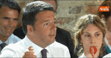a man in a white shirt and tie is talking to a woman in a white shirt and tie