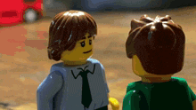 two lego figures are standing next to each other and one of them has a w on his shirt