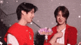 a couple of young men are standing next to each other and talking .