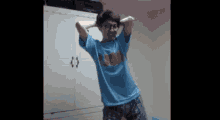 a man wearing glasses and a blue shirt is standing in front of a wardrobe .