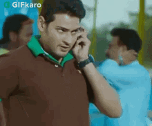 a man is talking on a cell phone while wearing a watch .