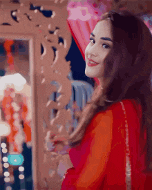 a woman is standing in front of a mirror and smiling .