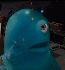 a close up of a blue cartoon character with a red eye