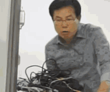 a man is standing in front of a bunch of wires and cables .