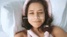 a woman laying on a bed with the words " good morning bbyys " on her face