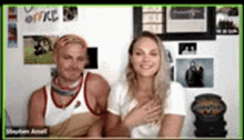 a man and a woman are sitting next to each other in a room .