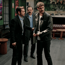 a man holding a gun talks to two other men