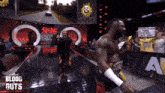 two wrestlers are walking down a ramp with a sign that says blood guts in the background