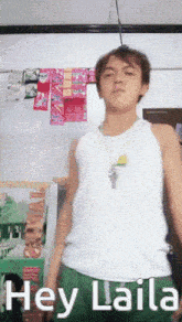 a man wearing a white tank top and green shorts says hey laila