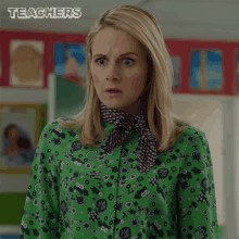 a woman wearing a green shirt with a scarf around her neck and the word teachers on the bottom