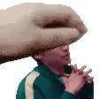 a man wearing a green jacket and a white hat is being hit by a large hand .