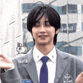 a man in a suit and tie with a pixelated bunny on his jacket and a name tag that says isa 3