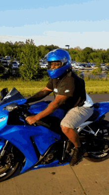 a man wearing a blue helmet is riding a motorcycle