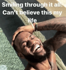 a man with a beard is smiling in a pool with the caption smiling through it all