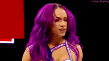 a woman with purple hair is making a funny face .