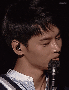 a close up of a person 's face with a microphone in his mouth