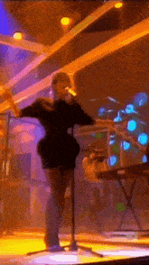 a woman singing into a microphone on a stage