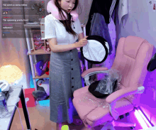 a woman is standing in front of a pink chair and a screen says tiki send us some lobbies
