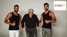 three men are dancing in front of a sign that says aaaart