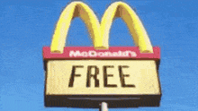a mcdonald 's sign that says `` free '' is against a blue sky .