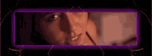 a woman 's face is framed by a purple light