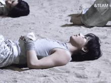 a person laying on a sandy beach with the words & team e on the bottom