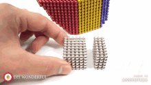 a person is playing with magnetic beads and the words diy wonderful are on the bottom of the screen