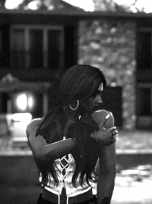 a black and white photo of a woman standing in front of a building