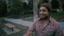 a man with a tattoo on his face is pointing at a tree