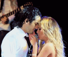 a man and a woman are kissing in front of a microphone and the words gifs portilla are on the bottom right