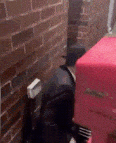 a brick wall with a red suitcase in front of it