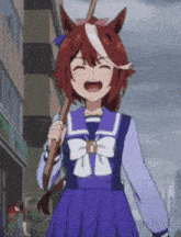 a girl in a sailor uniform is holding a stick and laughing .