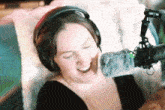 a woman wearing headphones and a microphone is smiling