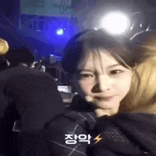 a woman is making a funny face in front of a crowd with a lightning bolt in the corner