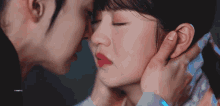 a man is touching a woman 's face with his hand .