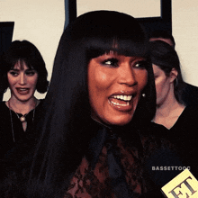 a woman is smiling while holding a microphone with the word et on it