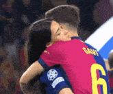 a woman is hugging a soccer player with the number 6 on his shirt