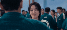 a man and a woman are looking at each other in front of a crowd of people .