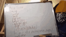 a person wearing a face mask holds up a whiteboard with russian writing on it