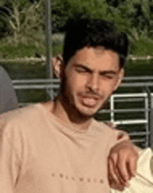 a young man in a pink t-shirt is standing next to a woman in a white shirt .