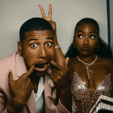 a man in a pink suit and a woman in a pink dress are posing for a photo with netflix written on the bottom