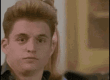 two young men are looking at each other in a room