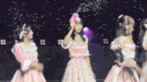a girl in a pink dress is holding a pink box