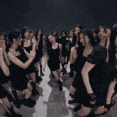 a group of women in black dresses are standing in a circle