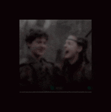 a boy and a girl are smiling and laughing in a blurry photo