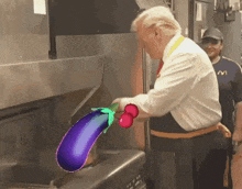 a man in a mcdonald 's uniform is cooking a purple eggplant