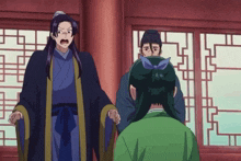 a man in a black robe is standing next to a woman in a green dress
