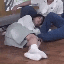 a person is laying on a wooden floor with their legs crossed .