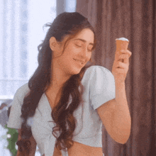 a woman is holding an ice cream cone in her hand and smiling
